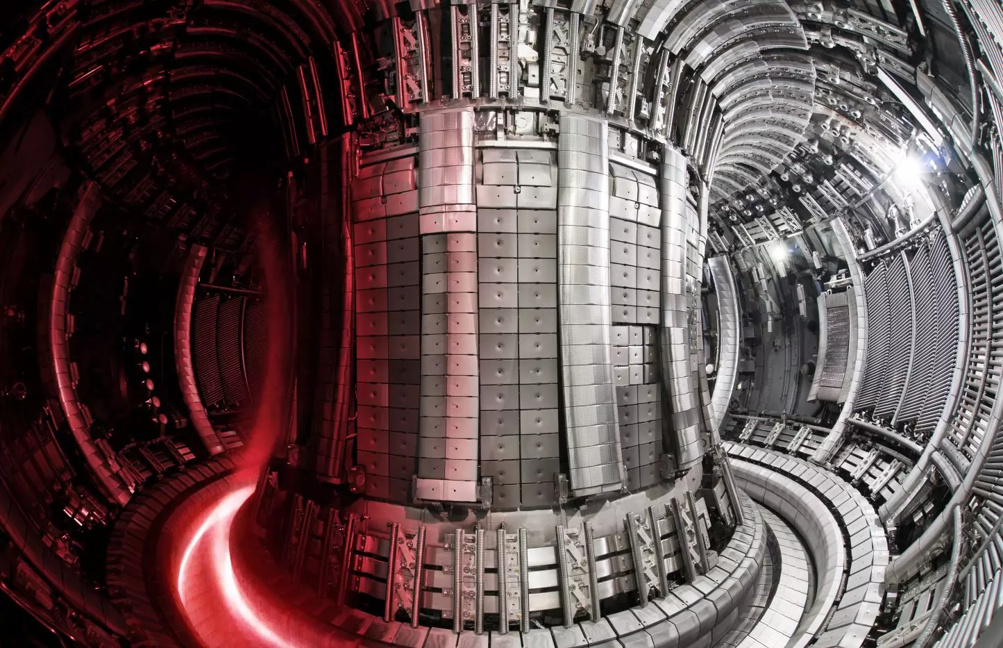 This picture shows a section of plasma (pink - authentic colour) superimposed on JET vessel equipped with the ITER-like wall. In actuality the plasma would not be confined to a small section of the vessel as in this image, but would extend the whole way around. Credit: EUROfusion Consortium